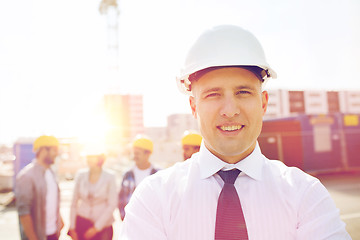 Image showing group of smiling builders in hardhats outdoors