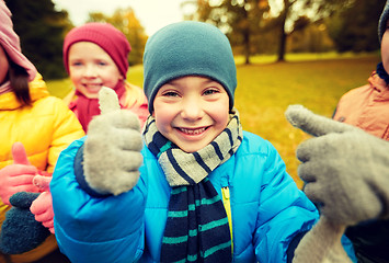 Image showing happy children showing thumbs up in autumn park