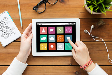 Image showing close up of woman with tablet pc on wooden table