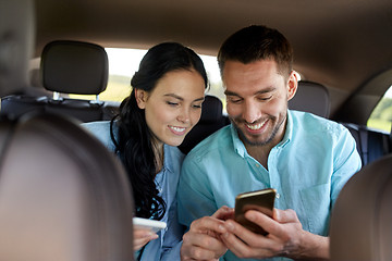 Image showing man and woman with smartphones driving in car