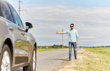 Image showing man hitchhiking and stopping car at countryside