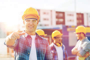 Image showing group of smiling builders in hardhats outdoors