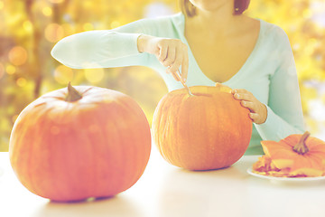 Image showing close up of woman carving pumpkins for halloween