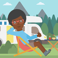 Image showing Woman sitting in chair in front of camper van.