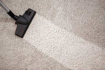 Image showing Head of vacuum cleaner in dusty carpet and clean strip