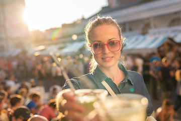 Image showing Beautiful young girl toasting on outdoor urban event.