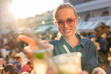 Image showing Beautiful young girl toasting on outdoor urban event.