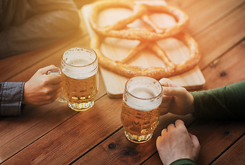 Image showing close up of hands with beer mugs at bar or pub