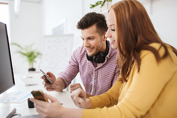 Image showing happy creative team with smartphones at office