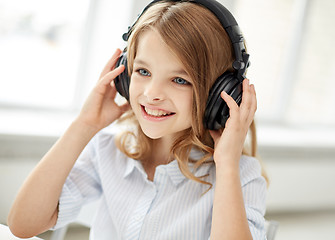 Image showing smiling little girl with headphones at home