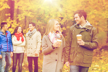 Image showing group of smiling friend with coffee cups in park