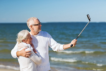 Image showing happy senior couple hugging on summer beach