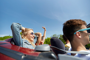 Image showing happy friends driving in cabriolet car at country