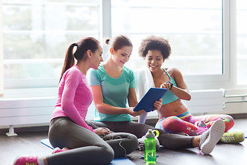 Image showing group of happy women with tablet pc in gym