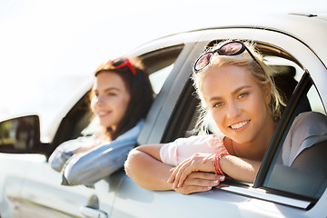 Image showing happy teenage girls or women in car at seaside