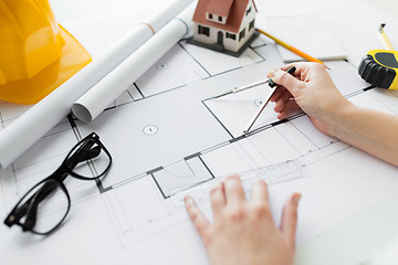 Image showing close up of hands with compass measuring blueprint