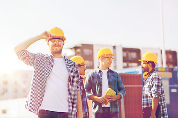 Image showing group of smiling builders in hardhats outdoors