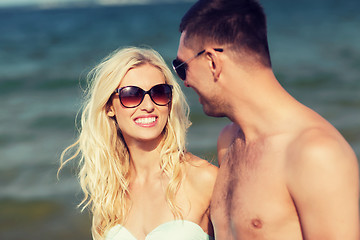 Image showing happy couple in swimwear walking on summer beach