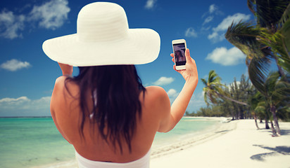 Image showing woman taking selfie with smartphone on beach