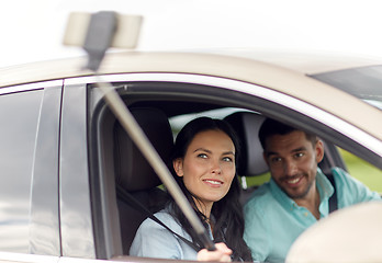 Image showing happy couple in car taking selfie with smartphone