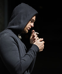 Image showing close up of addict lighting up marijuana joint