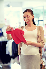 Image showing happy pregnant woman shopping at clothing store