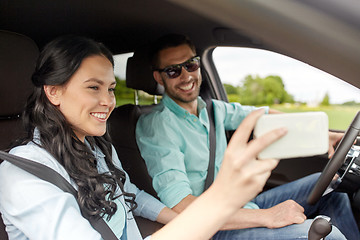 Image showing happy couple in car taking selfie with smartphone