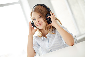 Image showing smiling little girl with headphones at home