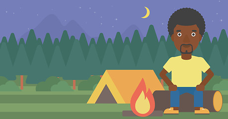 Image showing Man sitting on log in the camping.