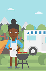 Image showing Woman having barbecue in front of camper van.