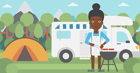 Image showing Woman having barbecue in front of camper van.