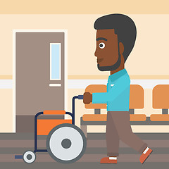 Image showing Man pushing wheelchair.