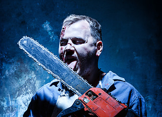 Image showing Bloody Halloween theme: crazy killer as butcher with electric saw