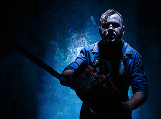 Image showing Bloody Halloween theme: crazy killer as butcher with electric saw