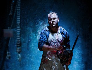 Image showing Bloody Halloween theme: crazy killer as butcher with electric saw