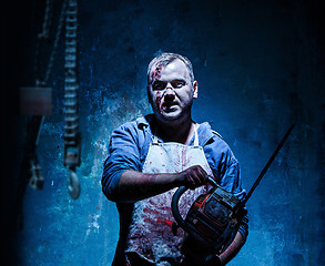 Image showing Bloody Halloween theme: crazy killer as butcher with electric saw