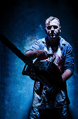 Image showing Bloody Halloween theme: crazy killer as butcher with electric saw