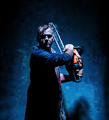 Image showing Bloody Halloween theme: crazy killer as butcher with electric saw