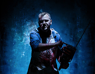 Image showing Bloody Halloween theme: crazy killer as butcher with electric saw