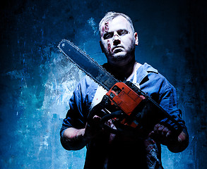 Image showing Bloody Halloween theme: crazy killer as butcher with electric saw