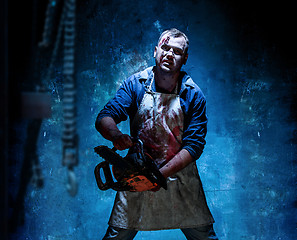 Image showing Bloody Halloween theme: crazy killer as butcher with electric saw