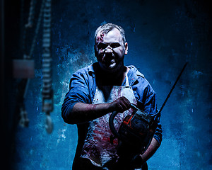 Image showing Bloody Halloween theme: crazy killer as butcher with electric saw