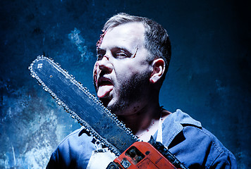 Image showing Bloody Halloween theme: crazy killer as butcher with electric saw