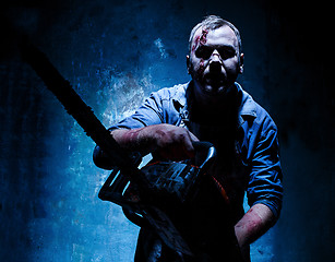 Image showing Bloody Halloween theme: crazy killer as butcher with electric saw