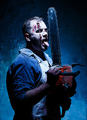 Image showing Bloody Halloween theme: crazy killer as butcher with electric saw