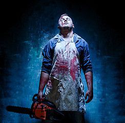 Image showing Bloody Halloween theme: crazy killer as butcher with electric saw