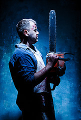 Image showing Bloody Halloween theme: crazy killer as butcher with electric saw