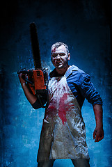 Image showing Bloody Halloween theme: crazy killer as butcher with electric saw