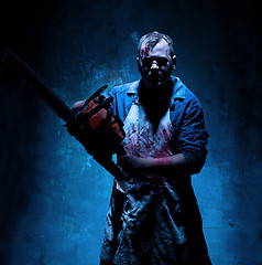 Image showing Bloody Halloween theme: crazy killer as butcher with electric saw