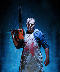 Image showing Bloody Halloween theme: crazy killer as butcher with electric saw